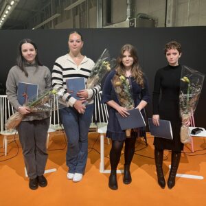 På bilden står fyra unga tjejer på rad på en scen. De håller alla i varsin blombukett och diplom.