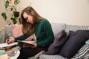En ung kvinna fotograferad i en randig soffa, sittande i profil.