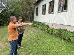 Vår fastighetsschef och ombudsman Åsa Rosenberg fotograferade utomhus i profil. De betraktar fasaden av ett ljusgrönt föreningshus i Åboland.