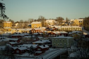 På helikopterbilden syns Borgå och gamla stan i Borgå. I förgrunden syns bron över Borgå å. Hustaken är täckta av snö och himlen är blekblå.