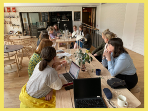 Praktikanter sitter runt ett bord och diskuterar under en praktikantträff i Paris.