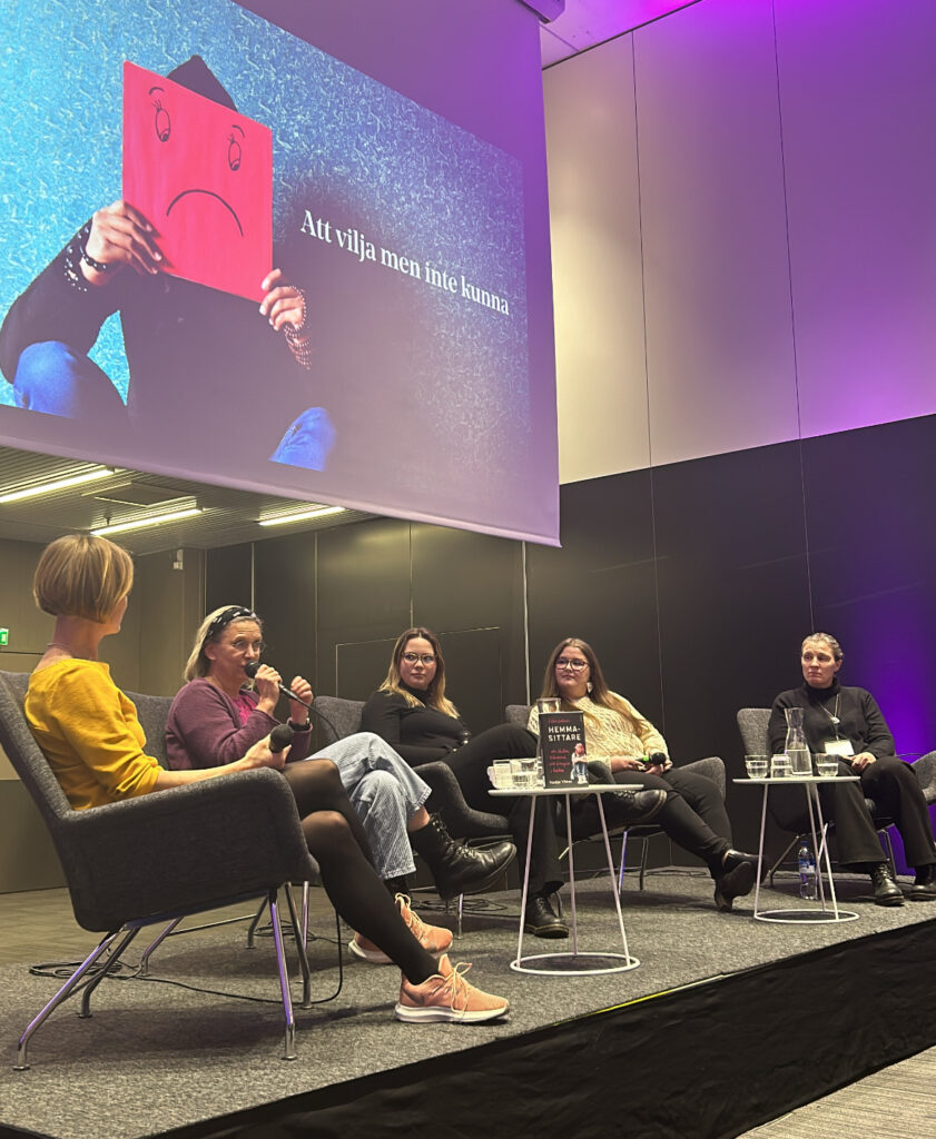 Fem panelister sitter på en scen och samtalar.
