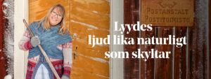 En kvinna i traditionell klädsel står på en snöig trappa och sopar snö. Hon ler mot kameran.
