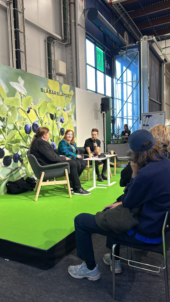 Tre personer sitter på en scen och samtalar.