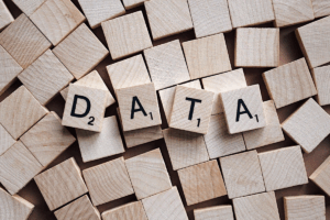 På bilden syns bokstavsbrickor ur spelet Alfapet. Brickorna har den blanka sidan uppåt, men fyra brickor visar bokstäver som tillsamman bilder ordet "DATA".